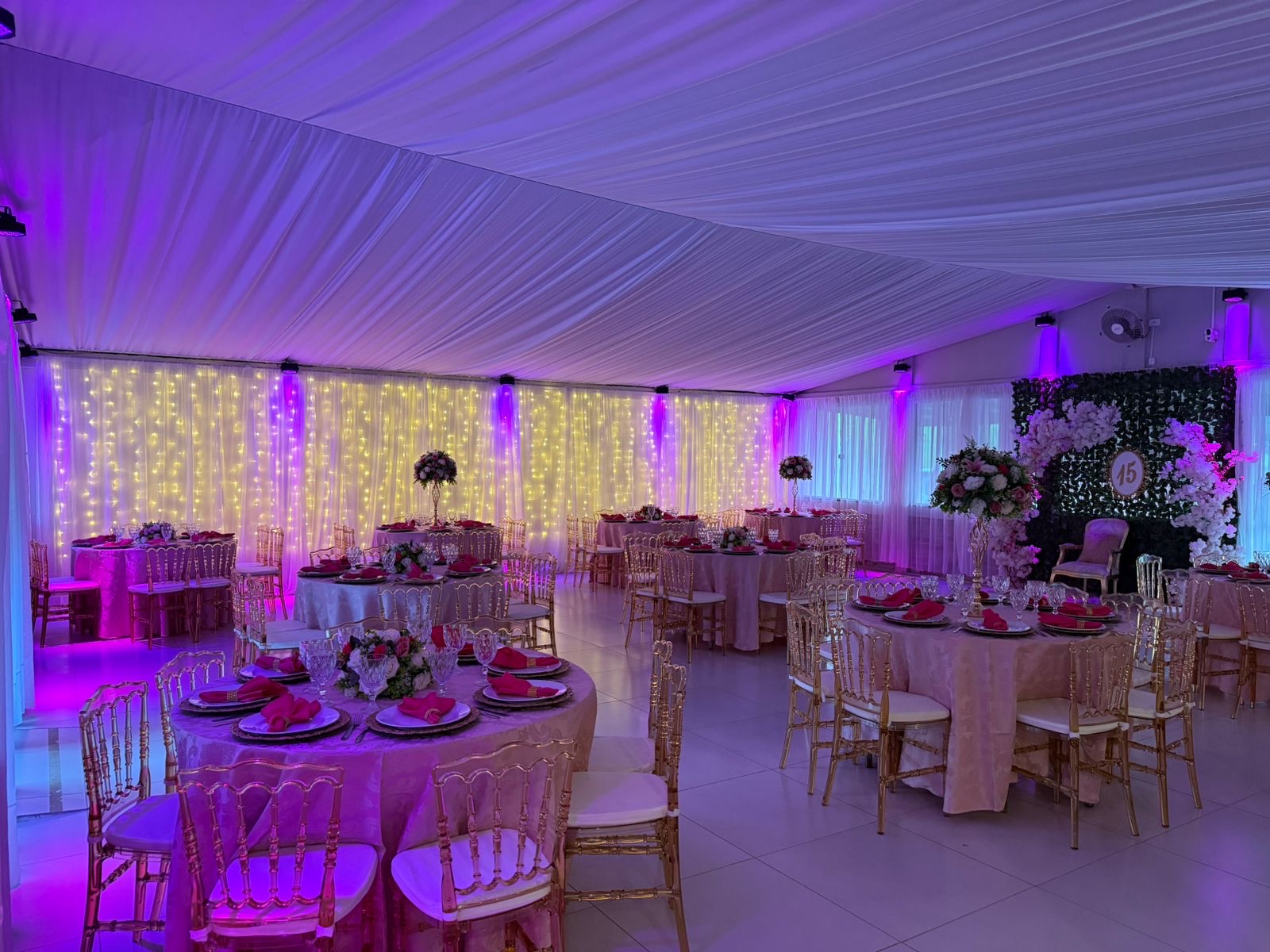 Salão com iluminação cênica rosa e cortina de luzes